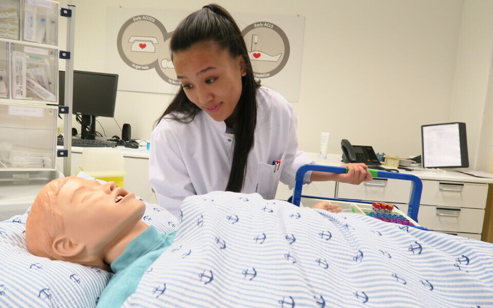 Sara Thien-Kieu Tran, tredje års bioingeniørstudent ved NTNU i Ålesund, sammen med dukken på simuleringssenteret. Foto: Sahar Olsen.