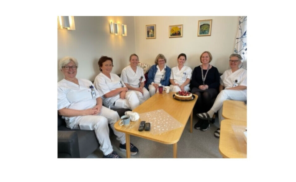Kryssordvinner Mette Korslund (i 'sivil'), klar for kakelunsj sammen med kollegene. Foto: Privat