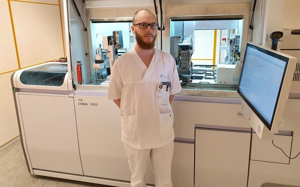 Øyvind Sebusæter foran det nye Cobas-instrumentet som skal brukes til koronaanalyser. Foto: Privat