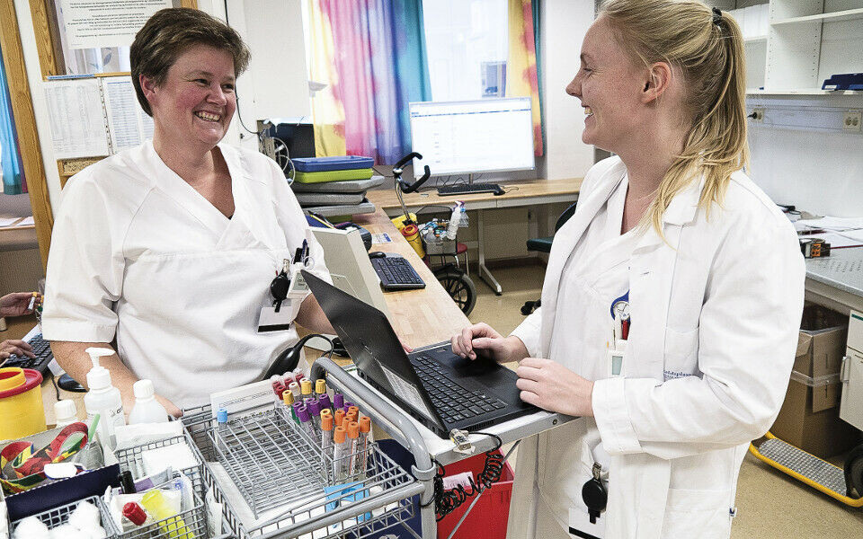 Anne Marit Fjeldstad (t.v.) og Lisbeth Johnsen er godt fornøyd med å ha egen «sykehusmobil» i lomma og PC plassert på prøvetakingstrallene. Slik kan de holde seg oppdatert seg til enhver tid. Foto: Grete Hansen