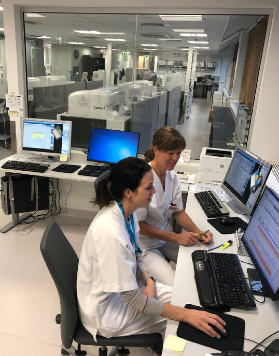 Fagansvarlig bioingeniør på Cobas Agnetha Roteigen og bioingeniør Hilde Myrvang Olsen trives i det flotte valideringsrommet som har full oversikt inn i analysehallen.