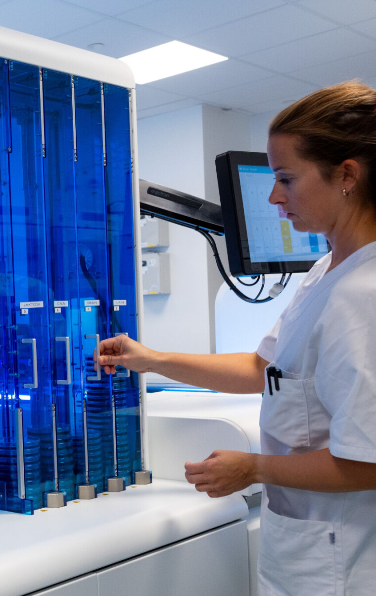 AUTOMASJON: Manuelt arbeid var hovedregelen på det gamle laboratoriet for mikrobiologi. På det nye skal rundt 80 prosent av prøvene håndteres automatisk. Drammen er det andre laboratoriet i Norge (etter Haukeland universitetssjukehus) som tar i bruk BD Kiestra automasjonsløsning, og de første som har fire arbeidsstasjoner koblet direkte til båndet. Fagbioingeniør Ida F. Evensen viser frem instrumentet.