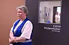 En kvinne står ved en dør merket Blodprodukter i en sykehuskorridor.