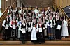 Stor gruppe personer i trapp, mange i tradisjonelle klær, holder diplomer.