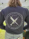Person bakfra med mørk genser med stort NTNU-emblem og kryssede symboler.